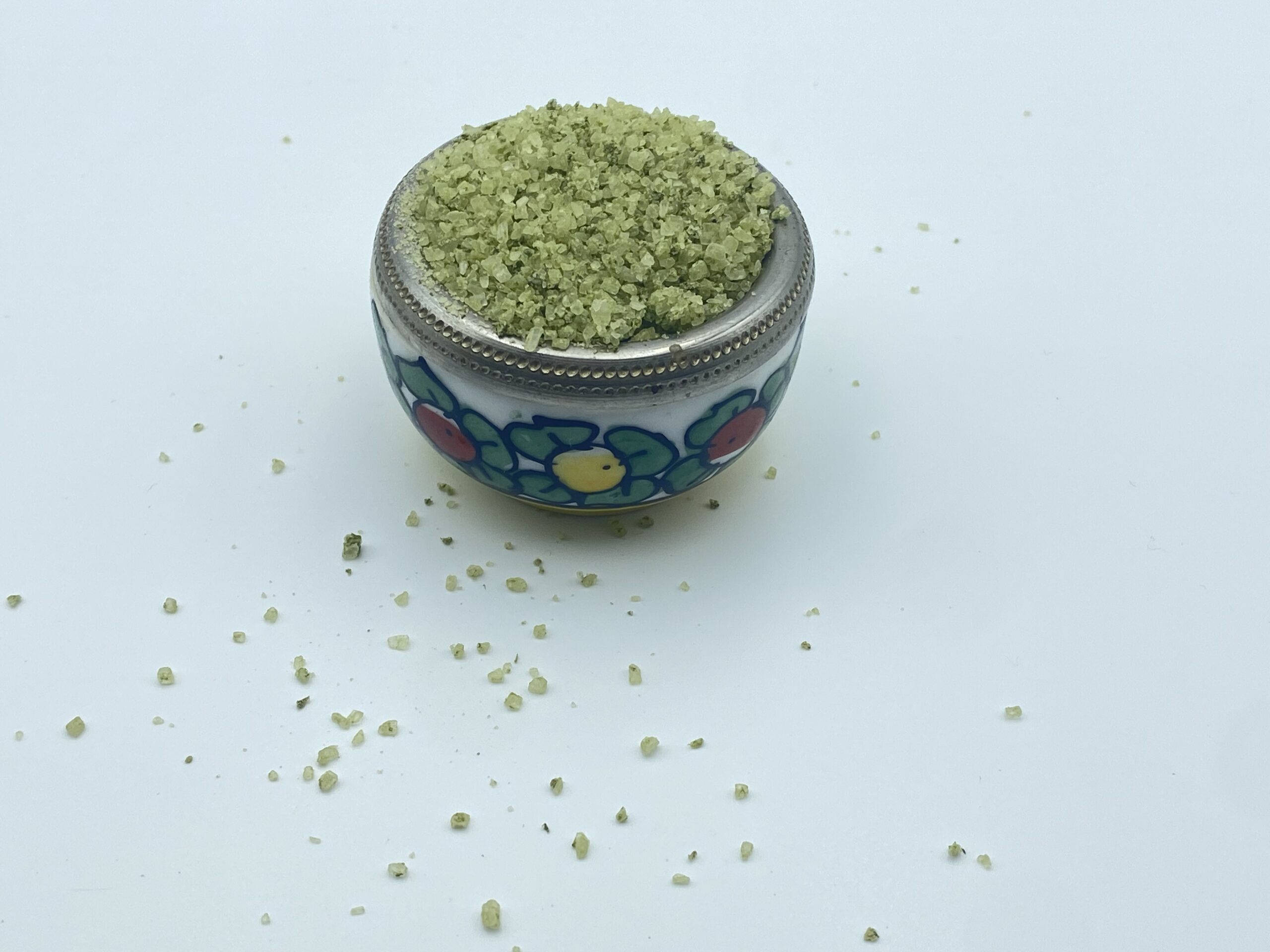 Herb salt in a small bowl with flowers painted on the sides