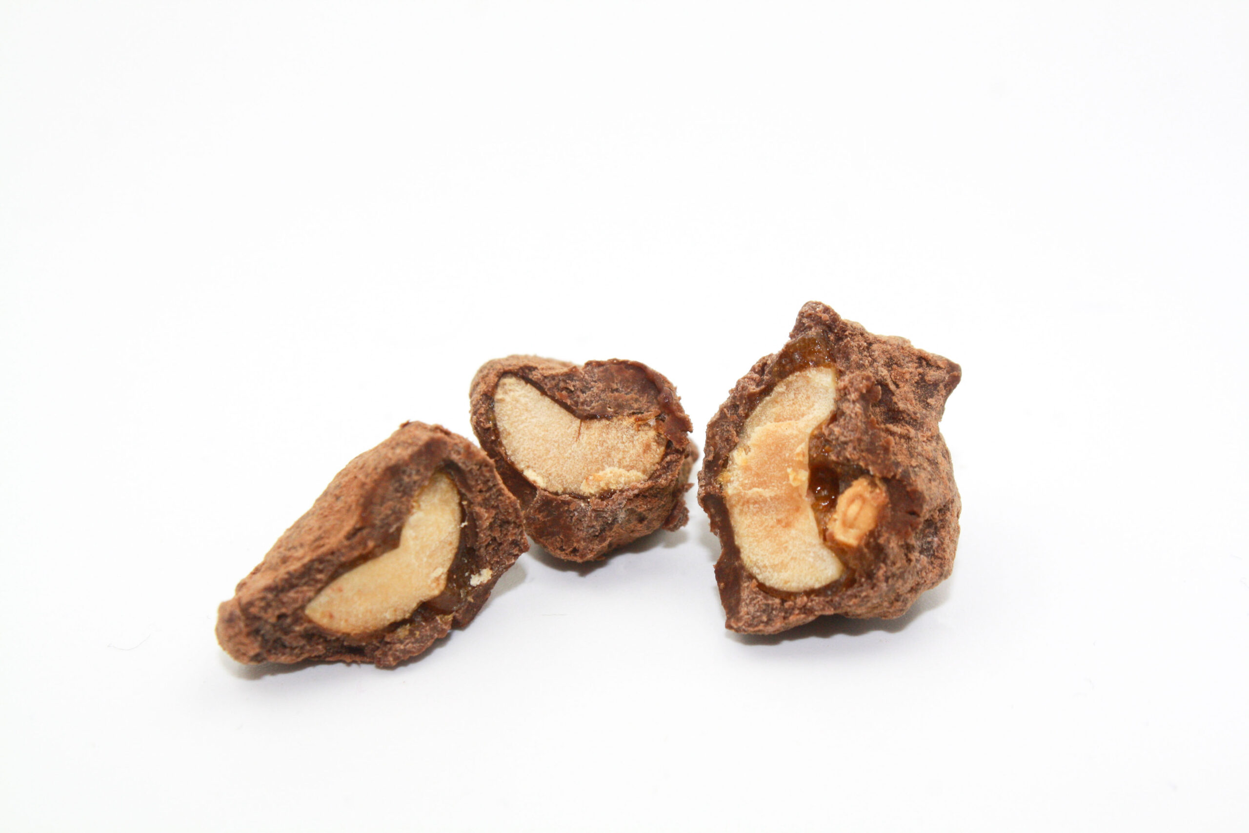 cross section view of the Dragée Peanuts showing the layers of peanut, caramel and chocolate
